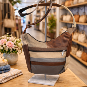 Image 1: Multi-color patchwork leather shoulder bag displayed on a stand with front zipper detail.