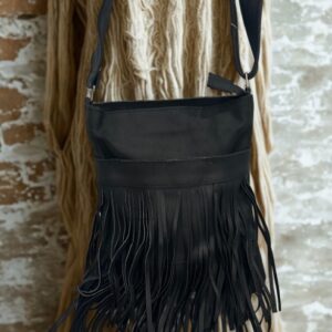 Image 1: Black leather fringe crossbody bag hanging on a display.