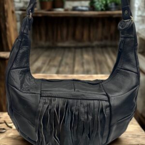 Image 1: Black leather patchwork shoulder bag with fringe and side zipper pocket.